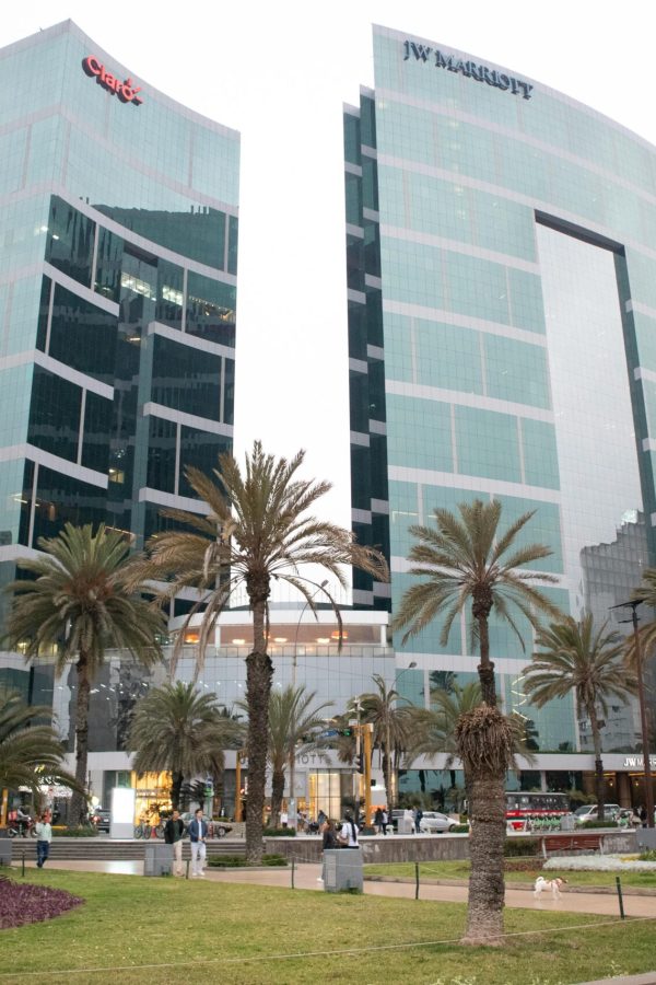Modern architecture of JW Marriott Hotel in downtown Lima, Peru, surrounded by palm trees.